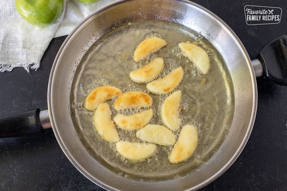 Cooking Apple Fries in a pan of oil.