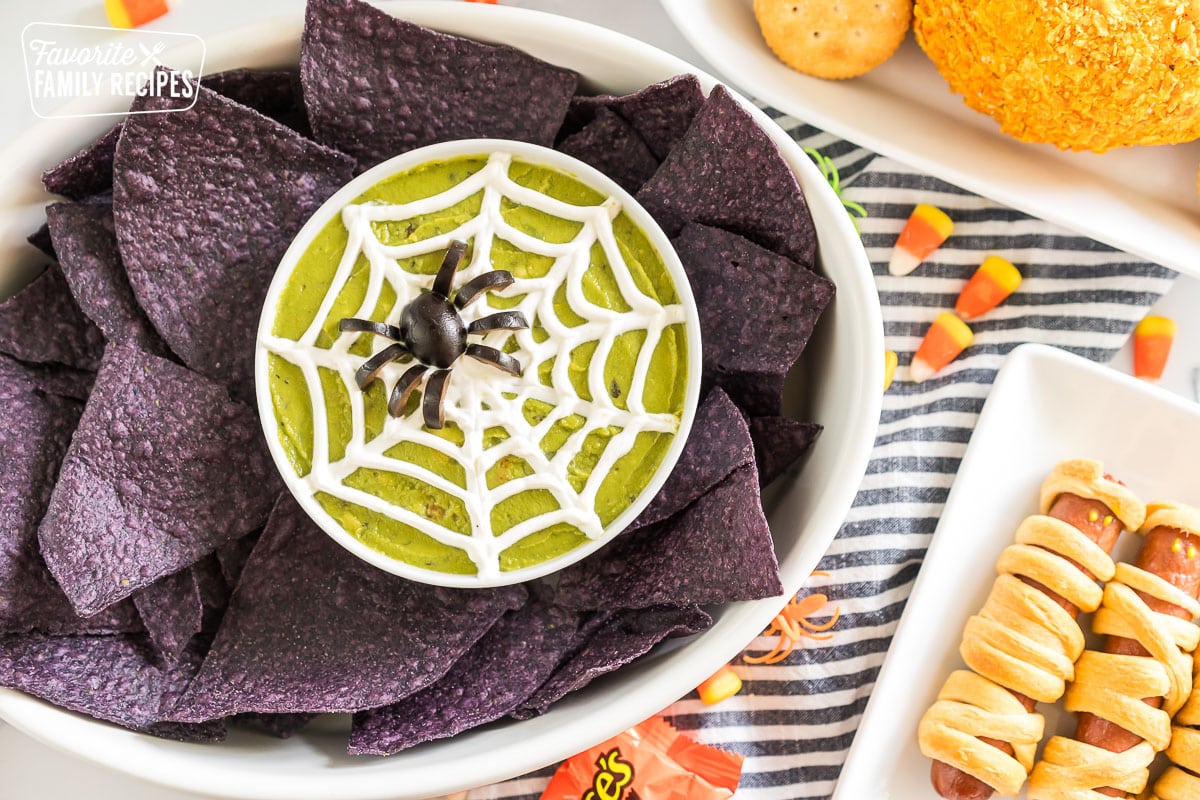 A spread of Halloween Appetizers on a table with halloween candy and spider rings