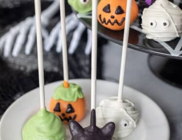 Plate with black cat, monster, mummy, and pumpkin Halloween Cake Pops.