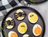 Black plates with assorted Halloween Deviled Eggs.