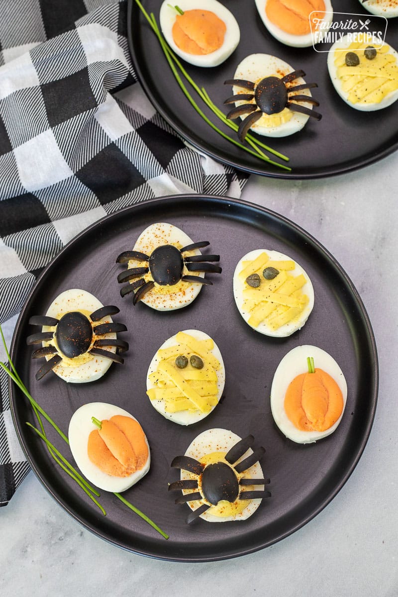 Black plates with assorted Halloween Deviled Eggs.