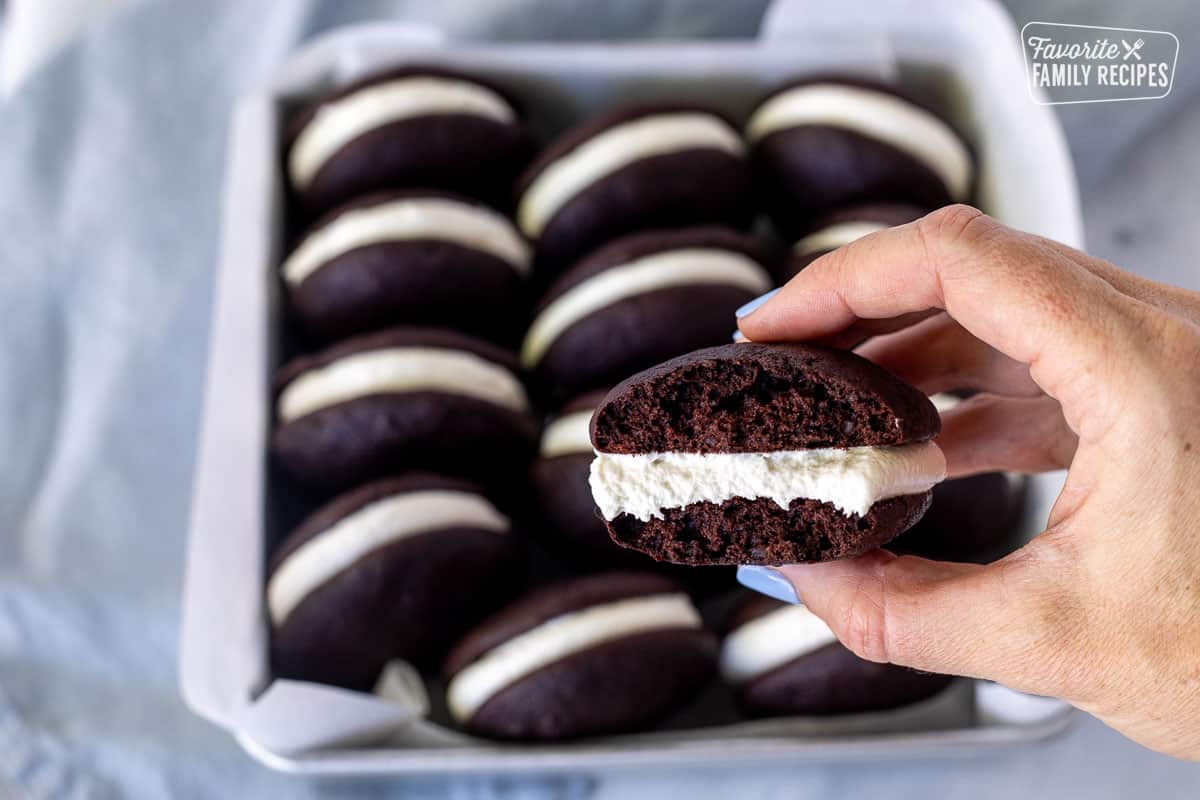 Hand holding a Whoopie Pie with a bite taken out.