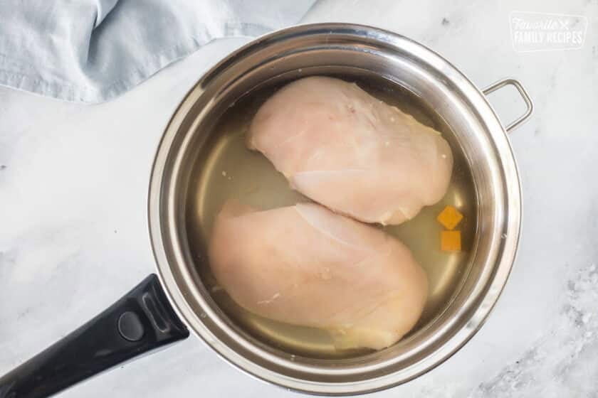 Pot with chicken breasts and bouillon cubes for Homemade Chicken Pot Pie.