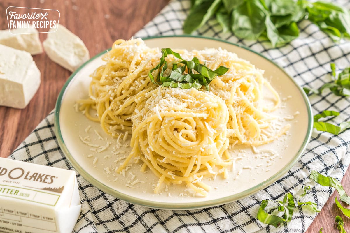 Noodles tossed with brown butter, mizithra cheese, and basil on a plate