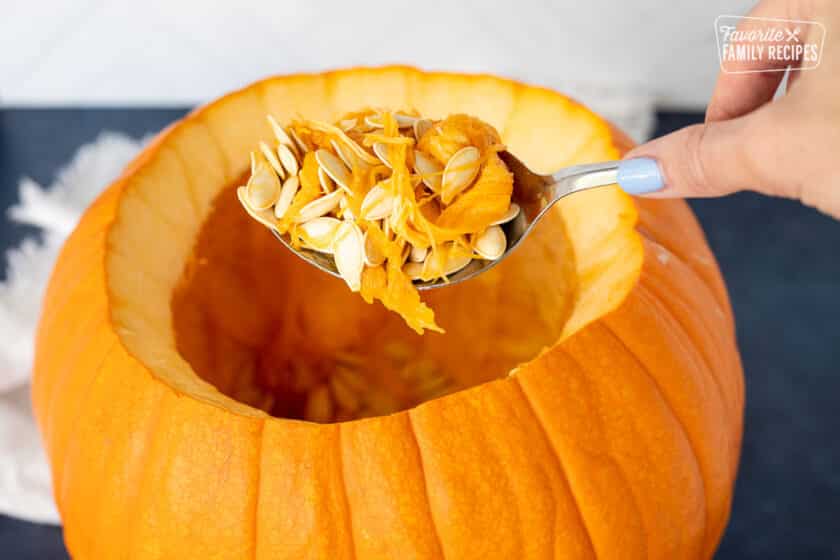 Scooping out the seeds from a pumpkin for soup.