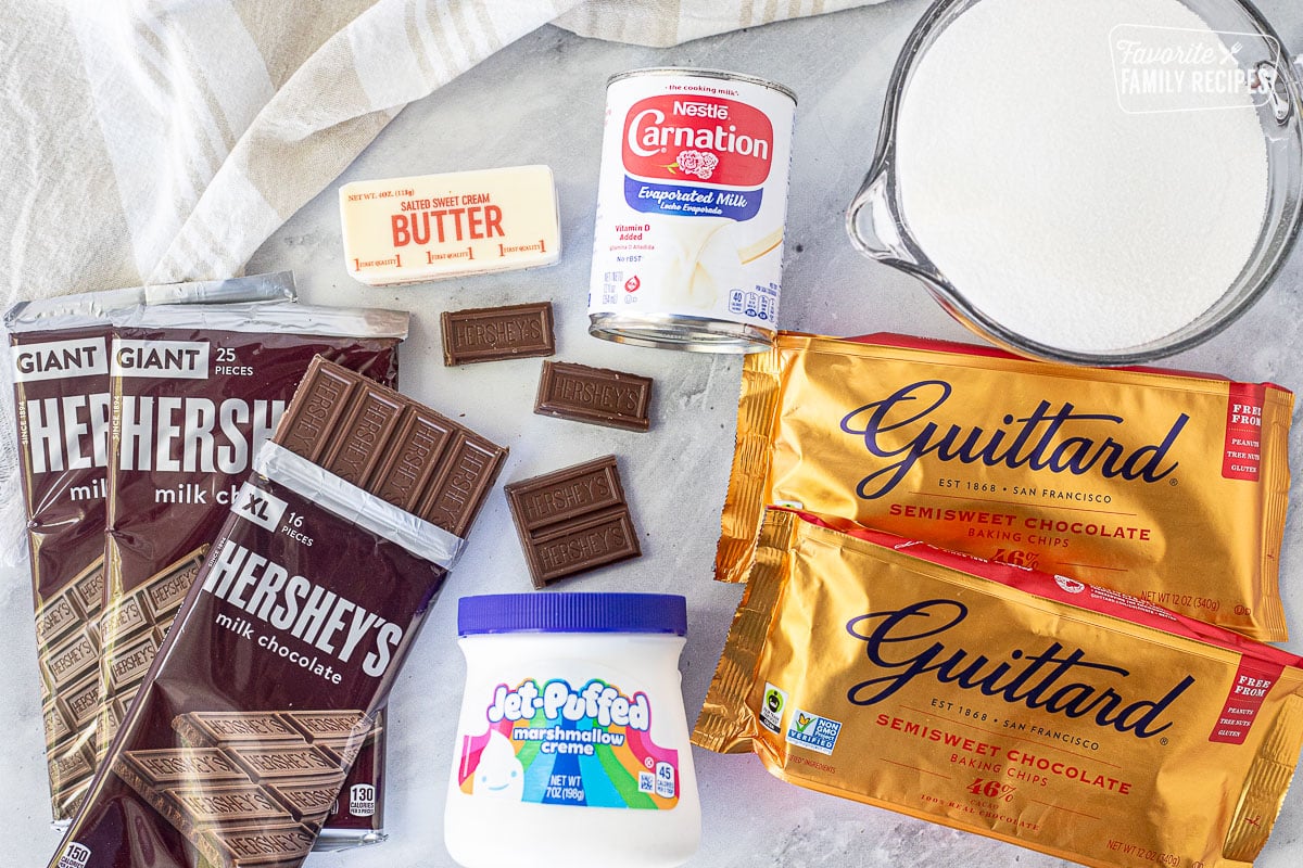 Ingredients to make See's Fudge including sugar, evaporated milk, butter, semisweet chocolate chips, marshmallow creme and Hershey's milk chocolate.
