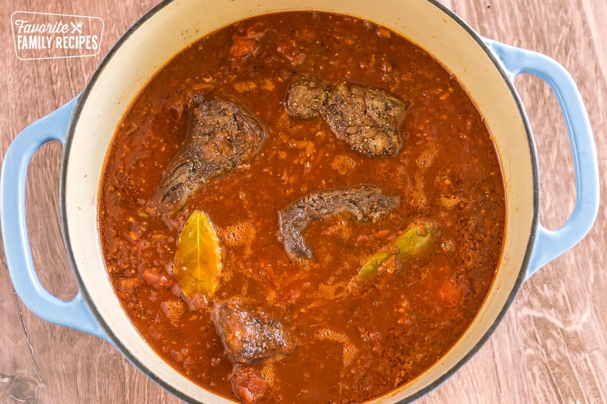 short ribs simmering in tomato sauce in a large pot