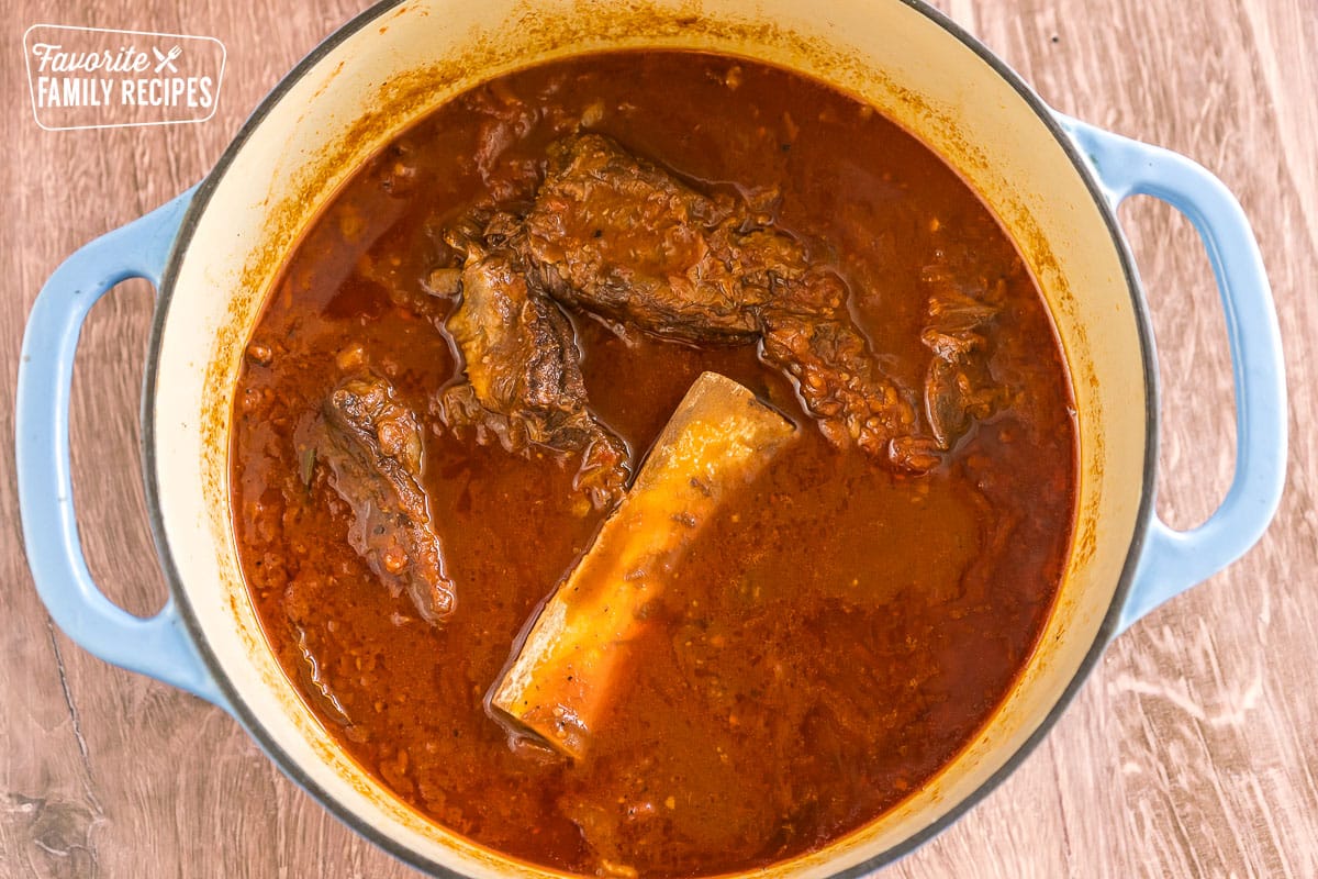 Sauce with short ribs floating on top in a large pot
