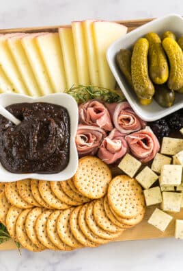 simple charcuterie board with meat, cheese, pickles, blackberries, crackers, and fig butter