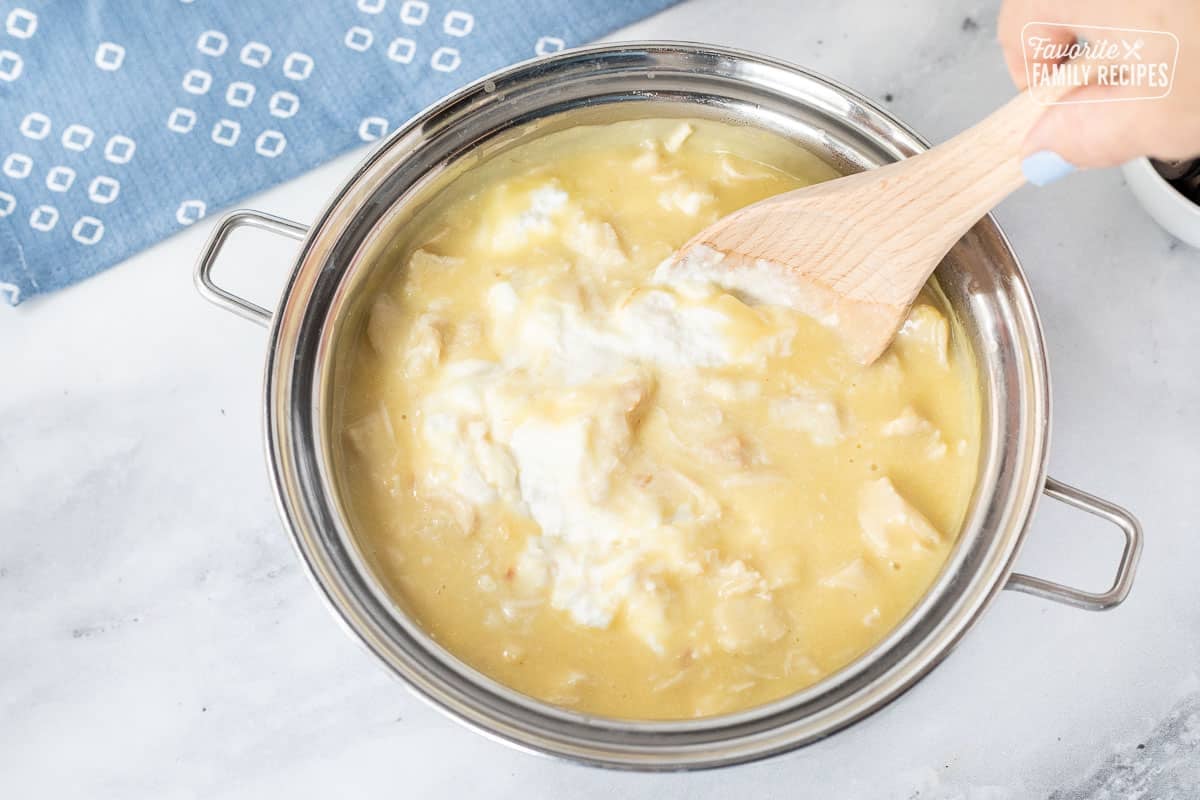 Stirring in sour cream to pan of Hawaiian Haystack chicken mixture.