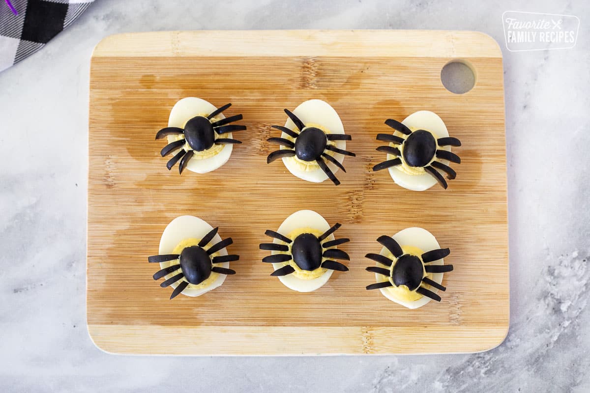 Six Spider Halloween Deviled Eggs on a cutting board.