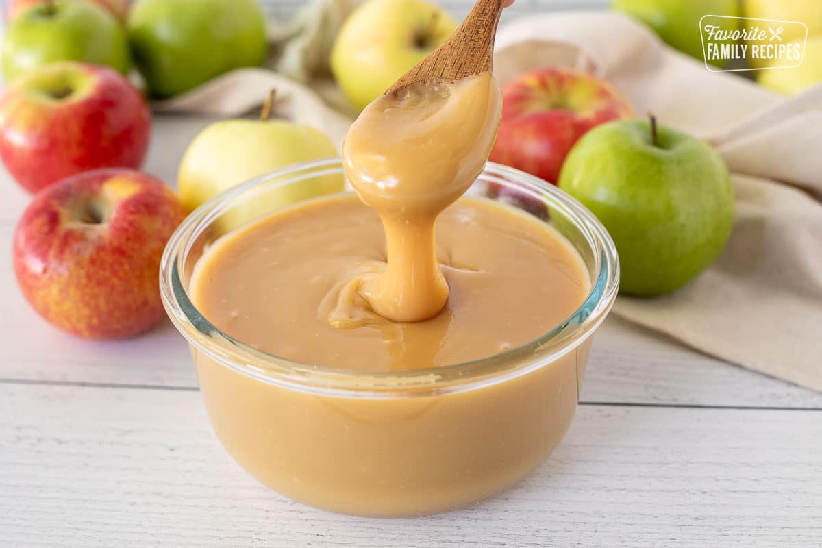 Spoon lifting Caramel Apple Dip from container.