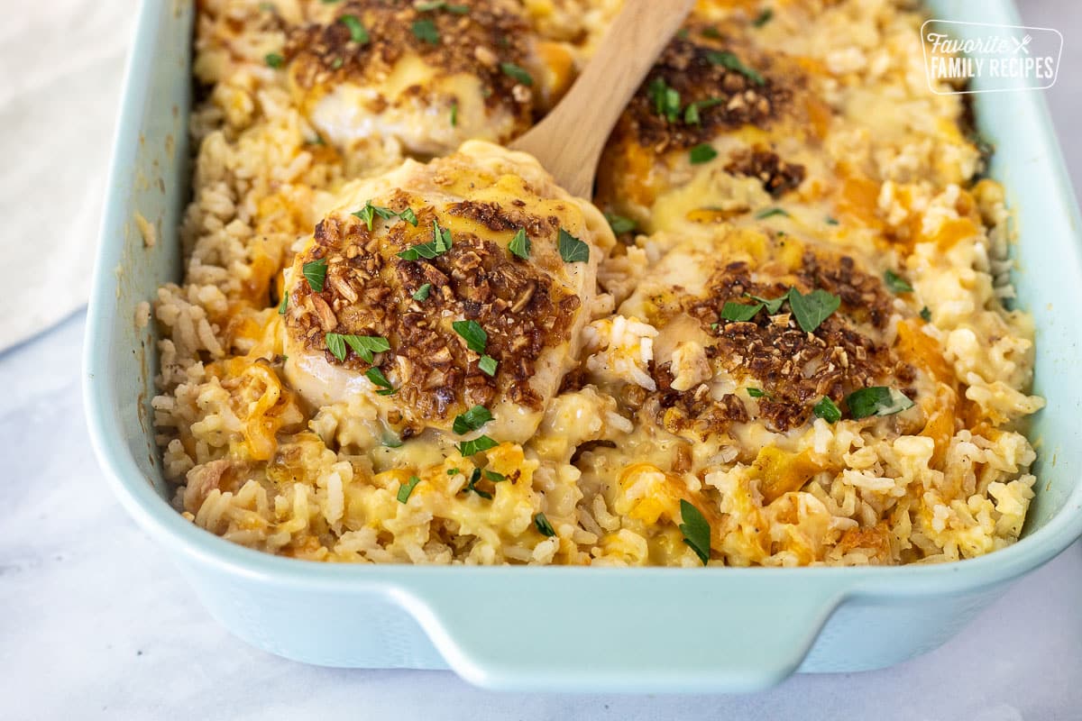 Spoon holding piece of chicken for Cheesy Chicken and Rice Casserole.