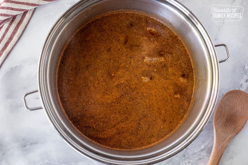 Large pot of beef broth, spices and meat for Texas Chili.