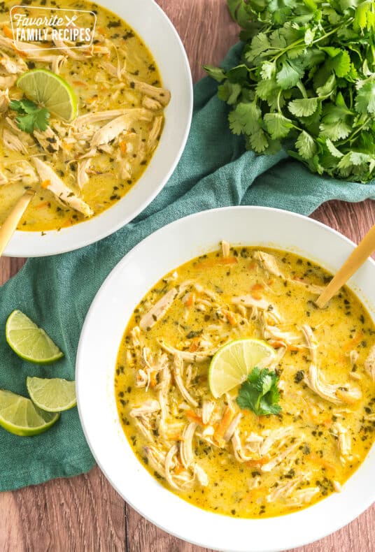 two bowls of thai coconut soup topped with lime and cilantro