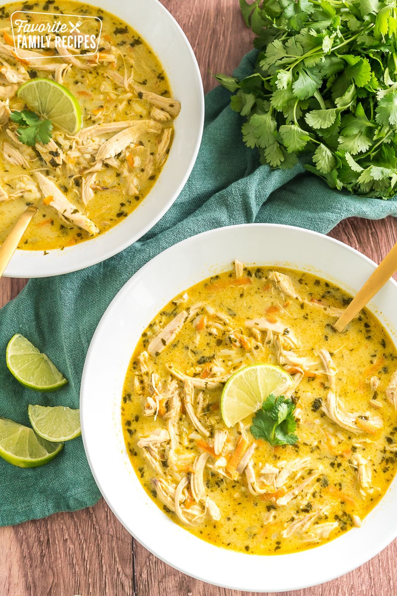 two bowls of thai coconut soup topped with lime and cilantro