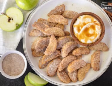 Apple Fries with cinnamon sugar next to a bowl of cream cheese caramel dip.