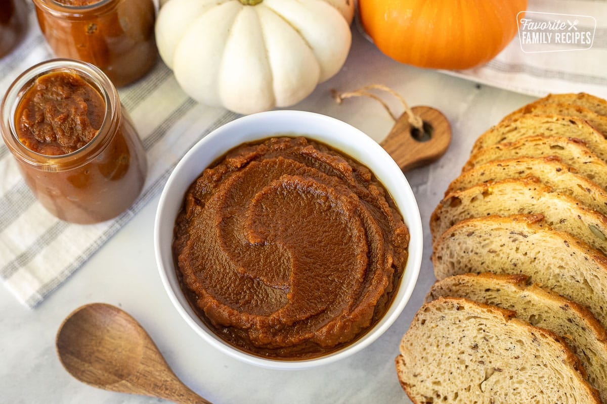 Bowl of Pumpkin Butter next to a jar of Pumpkin Butter and bread.
