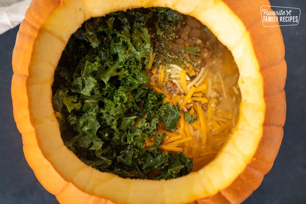 Kale, spices, cheeses, broth and sausage added into the Pumpkin for Soup.