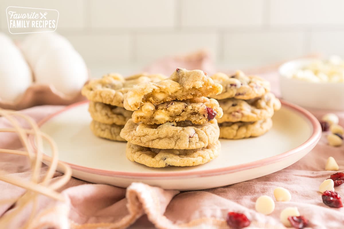 white chocolate cranberry cookies on a plate with one broken in half