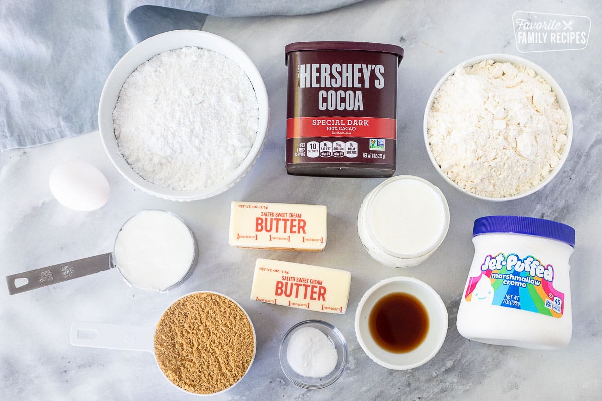 Ingrediens to make Whoopie Pies including powdered sugar, flour, dark cacao, shortening, egg, butter, brown sugar, salt, baking soda, vanilla, buttermilk, marshmallow creme.