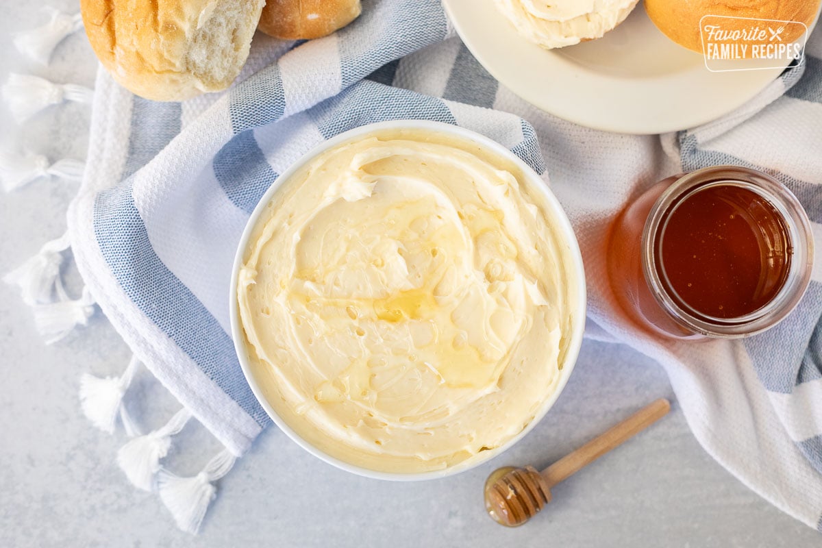 Bowl of Homemade Honey Butter drizzled with honey.