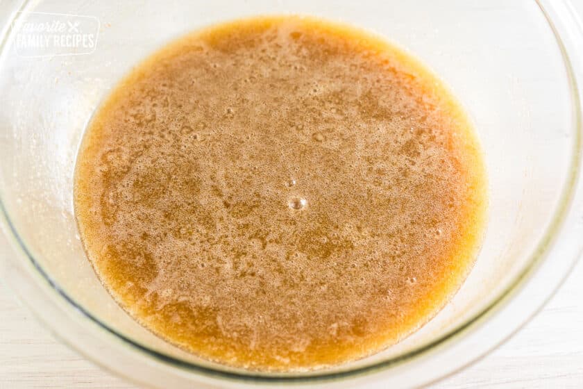 karo syrup, brown sugar, brown butter, eggs, vanilla, salt, and cinnamon mixed in a bowl