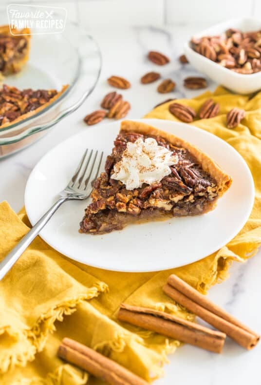 Brown Butter Pecan Pie on a plate topped with whipped cream