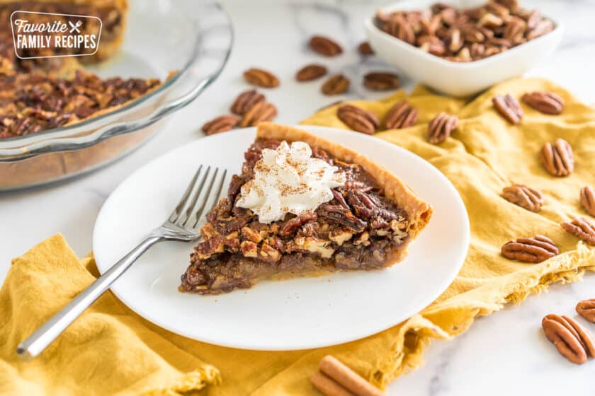 Brown Butter Pecan Pie on a plate topped with whipped cream