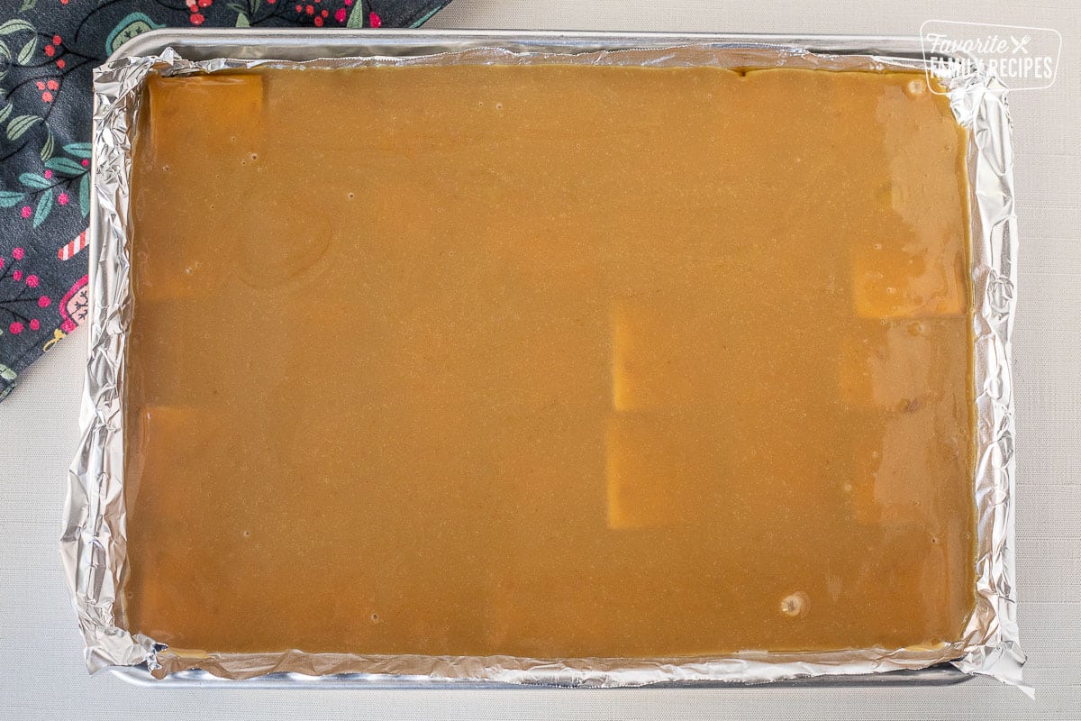 Carmel layer on top of saltine crackers in a foil lined baking sheet.