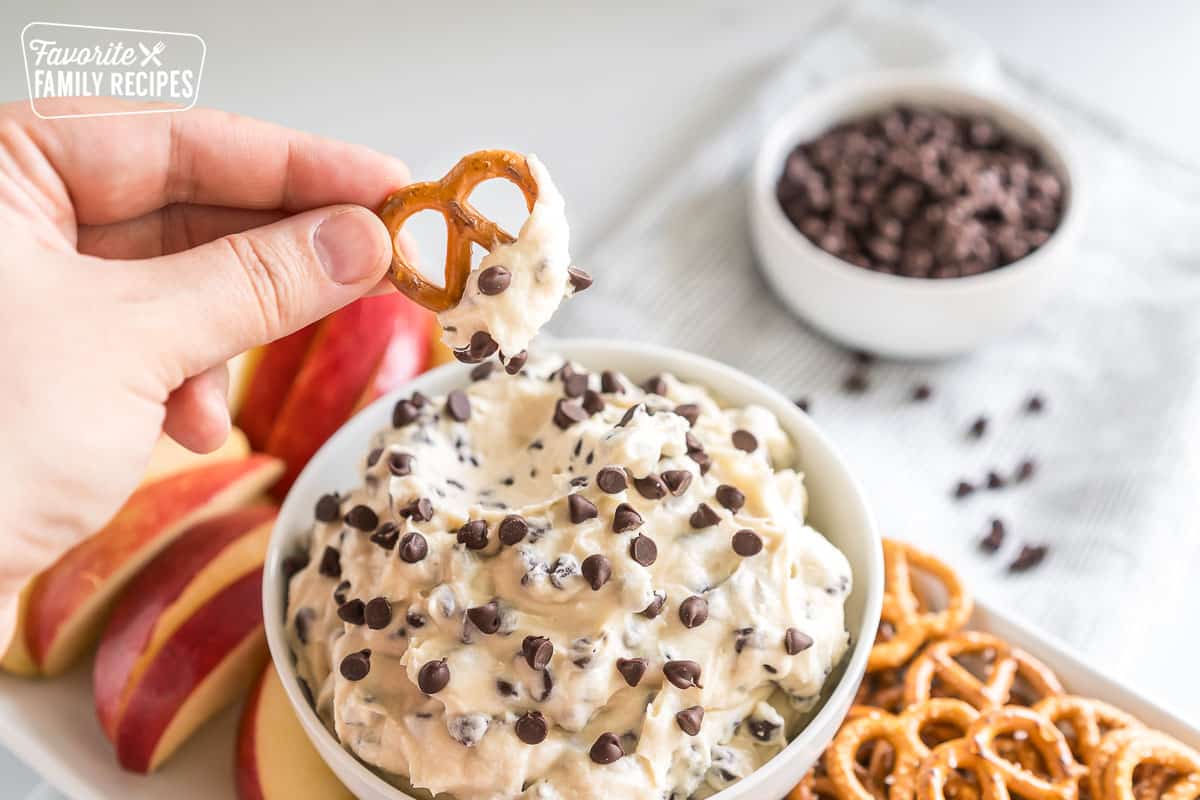a pretzel dipped in a sweet spread 