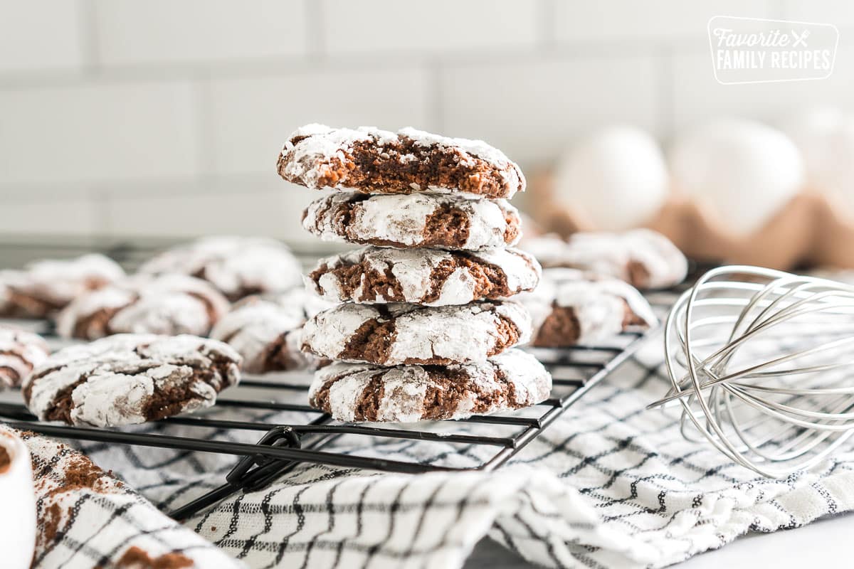 a stack of chocolate crinkle cookies with a bite taken out of one