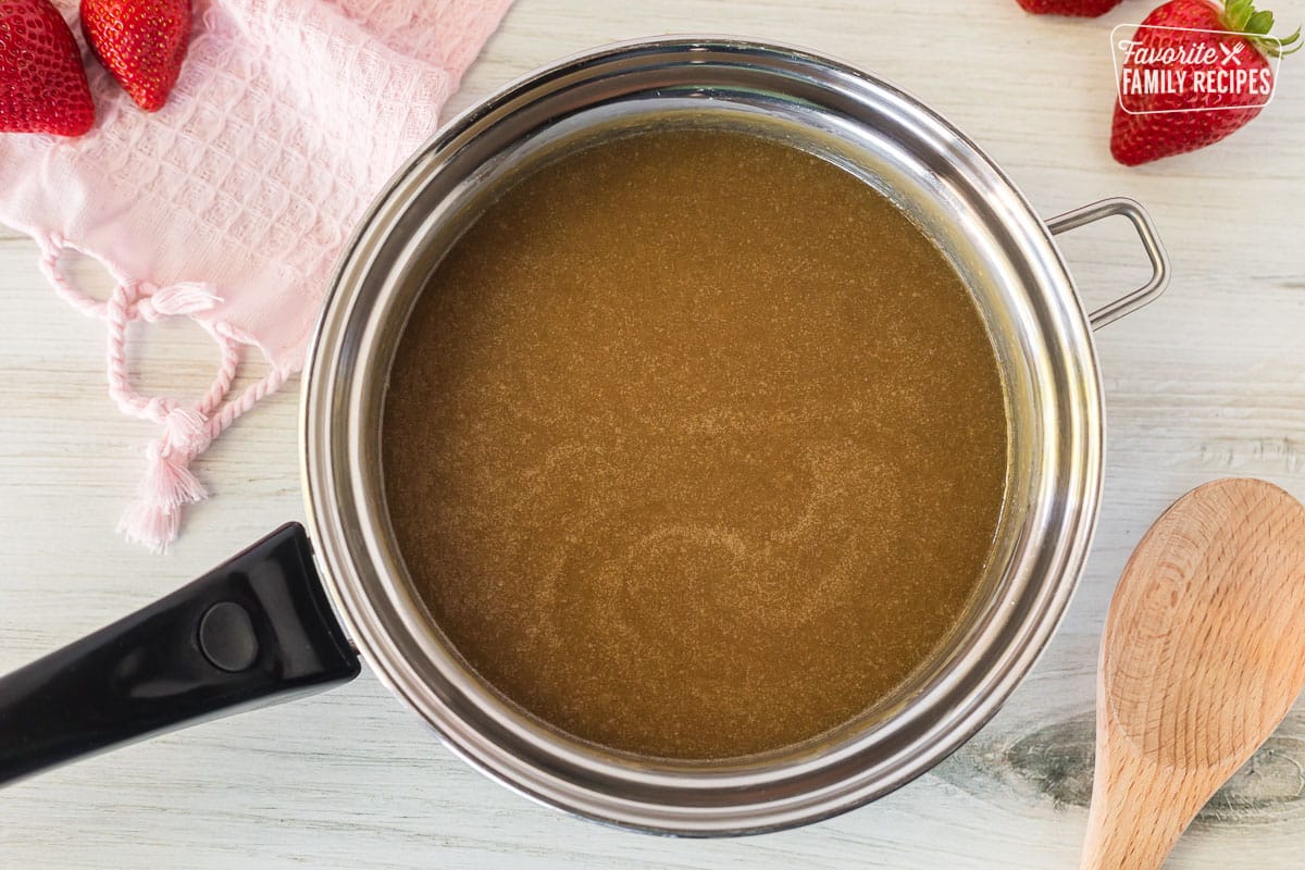 Pan with caramel syrup and wooden spoon on the side.