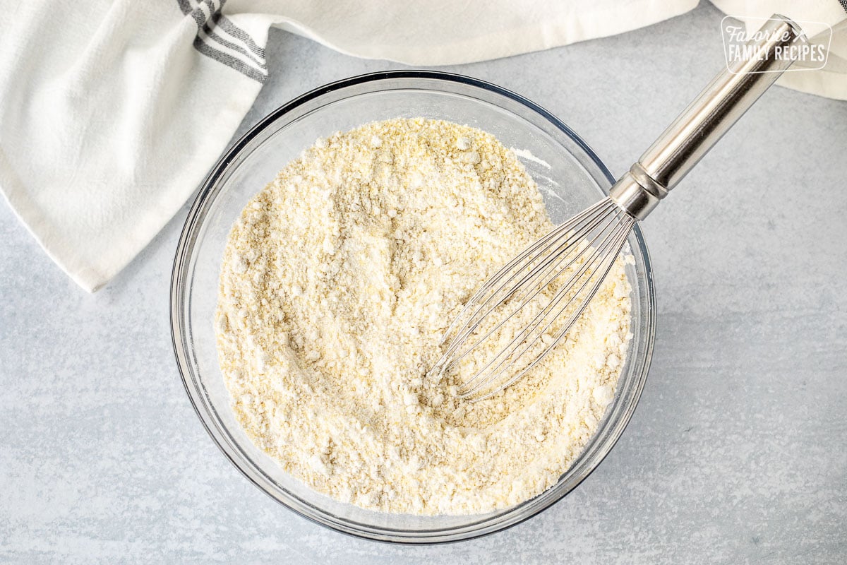 Bowl of dry ingredients for Cornbread combined with a whisk.