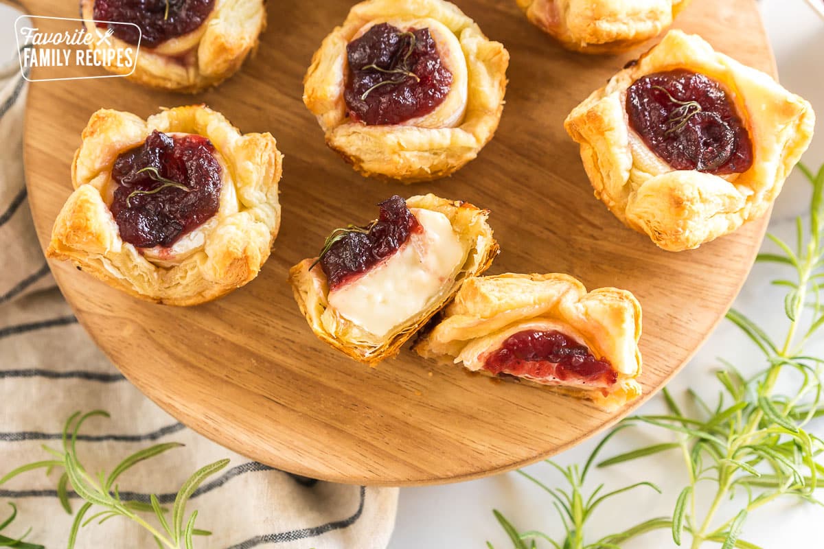 Cranberry Brie Bites on a wooden board with one cut in half