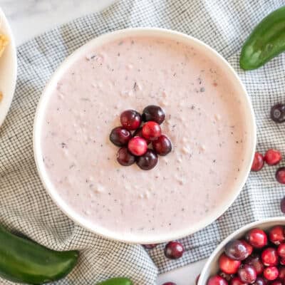 a bowl of cranberry jalapeno dip topped with cranberries