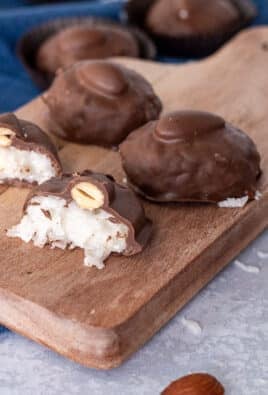 Almond Joys on a cutting board and one cut in half.