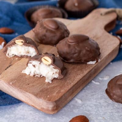 Almond Joys on a cutting board and one cut in half.