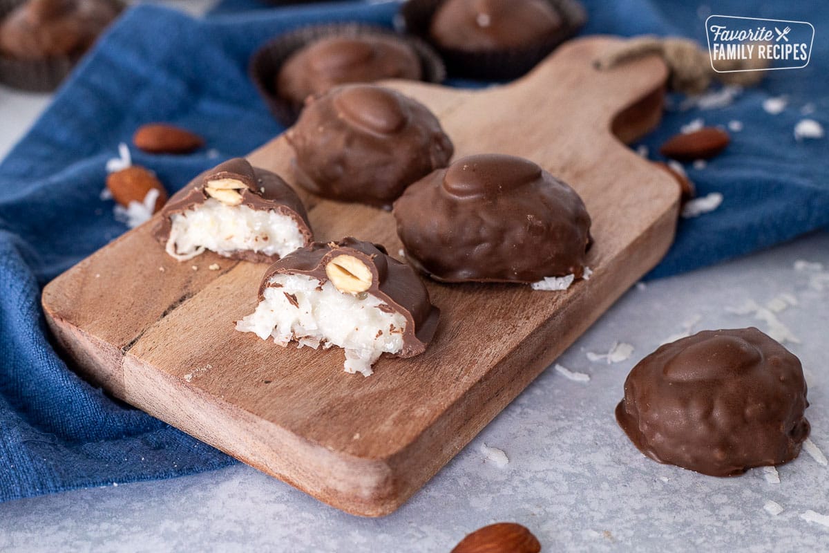 Almond Joys on a cutting board and one cut in half.