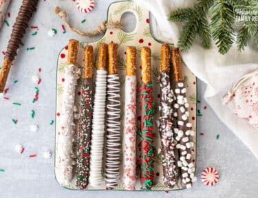 Christmas decorated Dipped Pretzel rods with sprinkles, crushed candy canes and marshmallow bits.