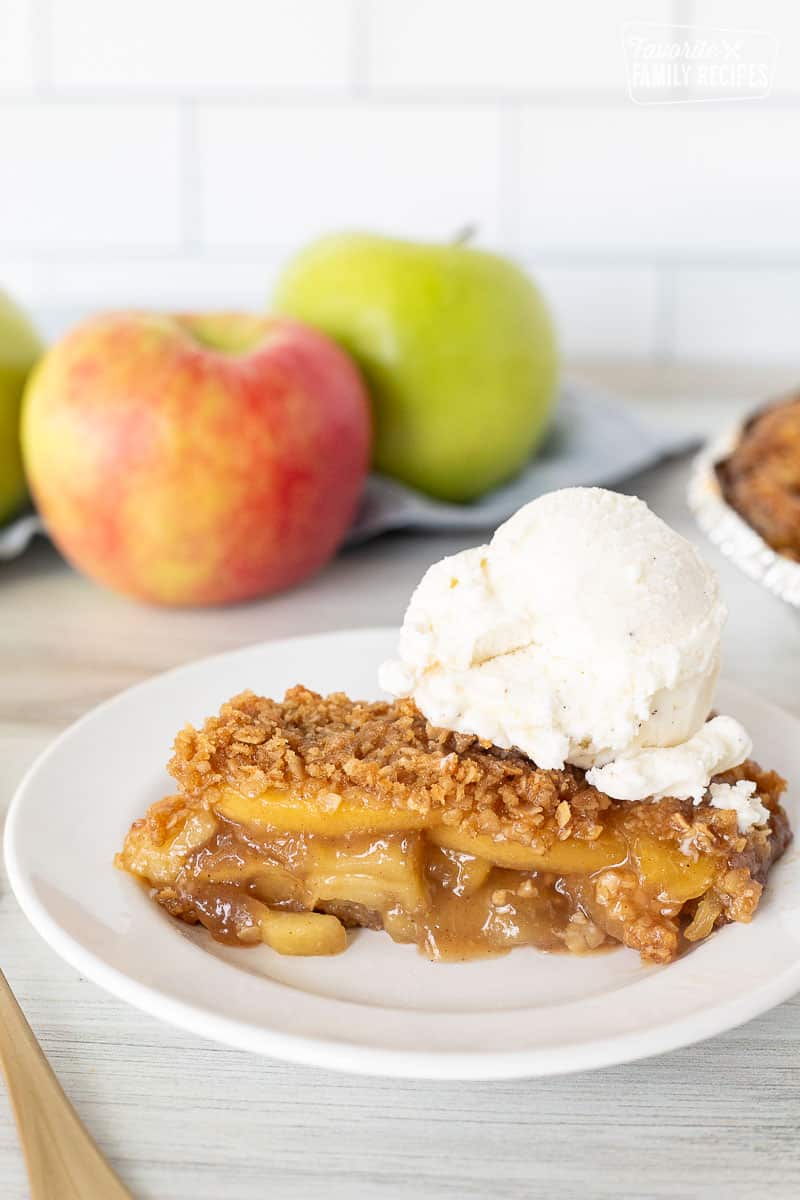 Slice of Gluten Free Apple Pie on a plate with a large scoop of vanilla ice cream on top.