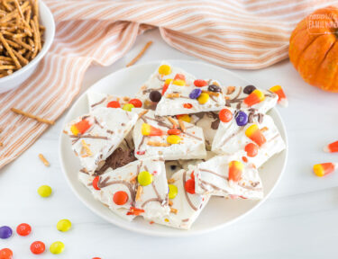 A side view of a plate filled with halloween candy bark.