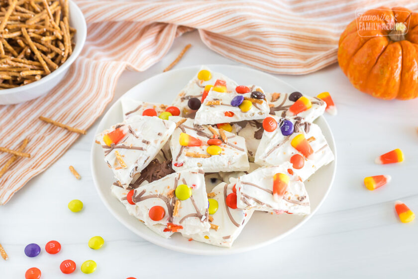 A side view of a plate filled with halloween candy bark.