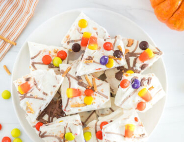 An overhead and vertical view of a plate filled with halloween candy bark.