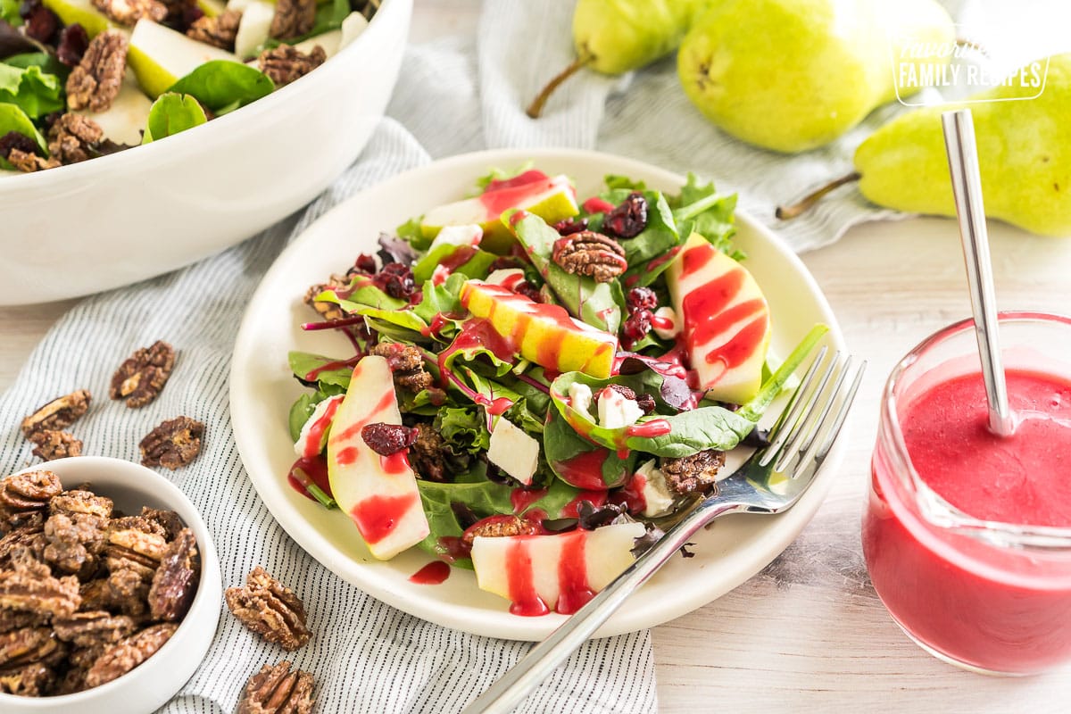 Harvest Pear Salad on a plate drizzled with cranberry vinaigrette dressing