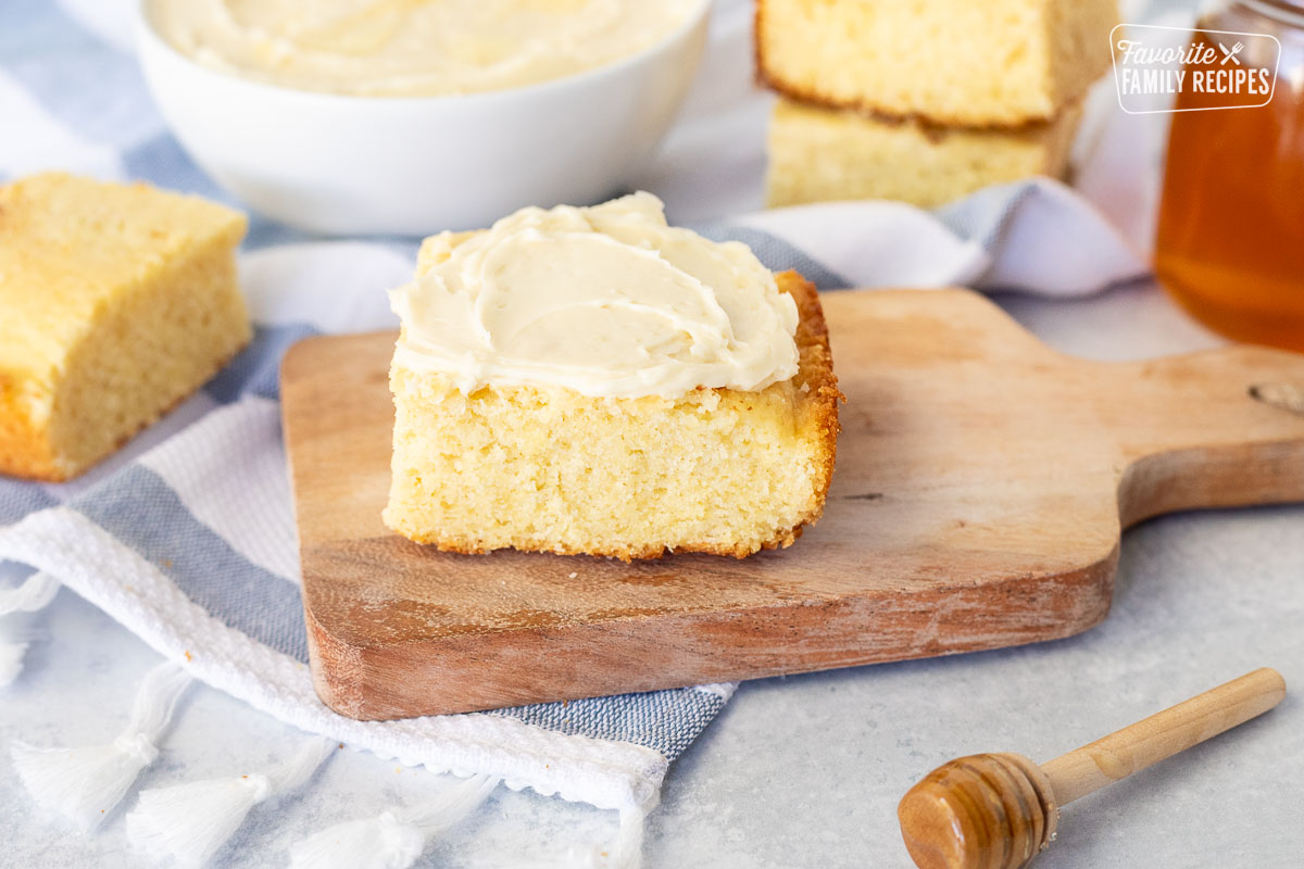 Slice of Cornbread with Homemade Honey Butter on top.