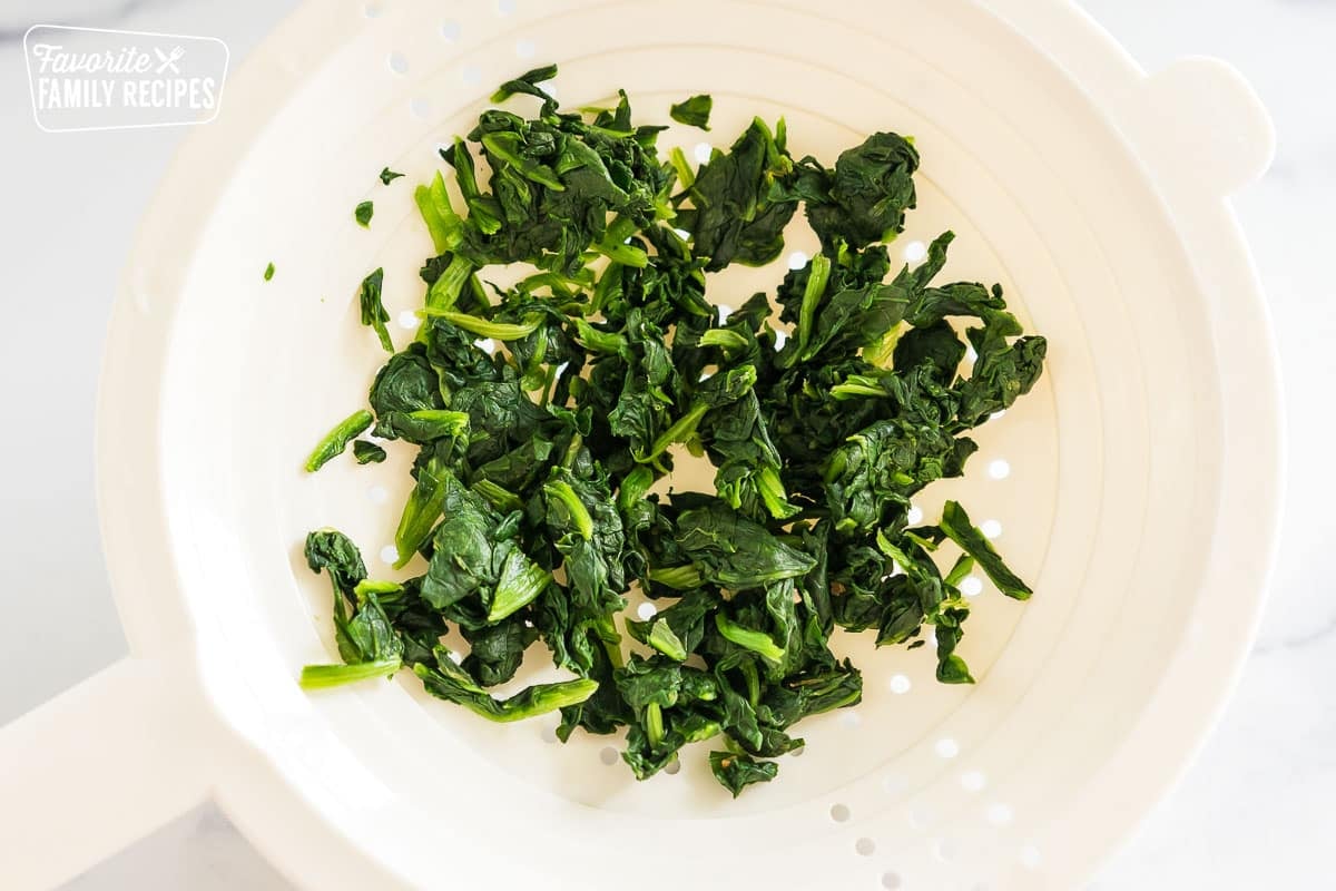 thawed frozen spinach in a strainer