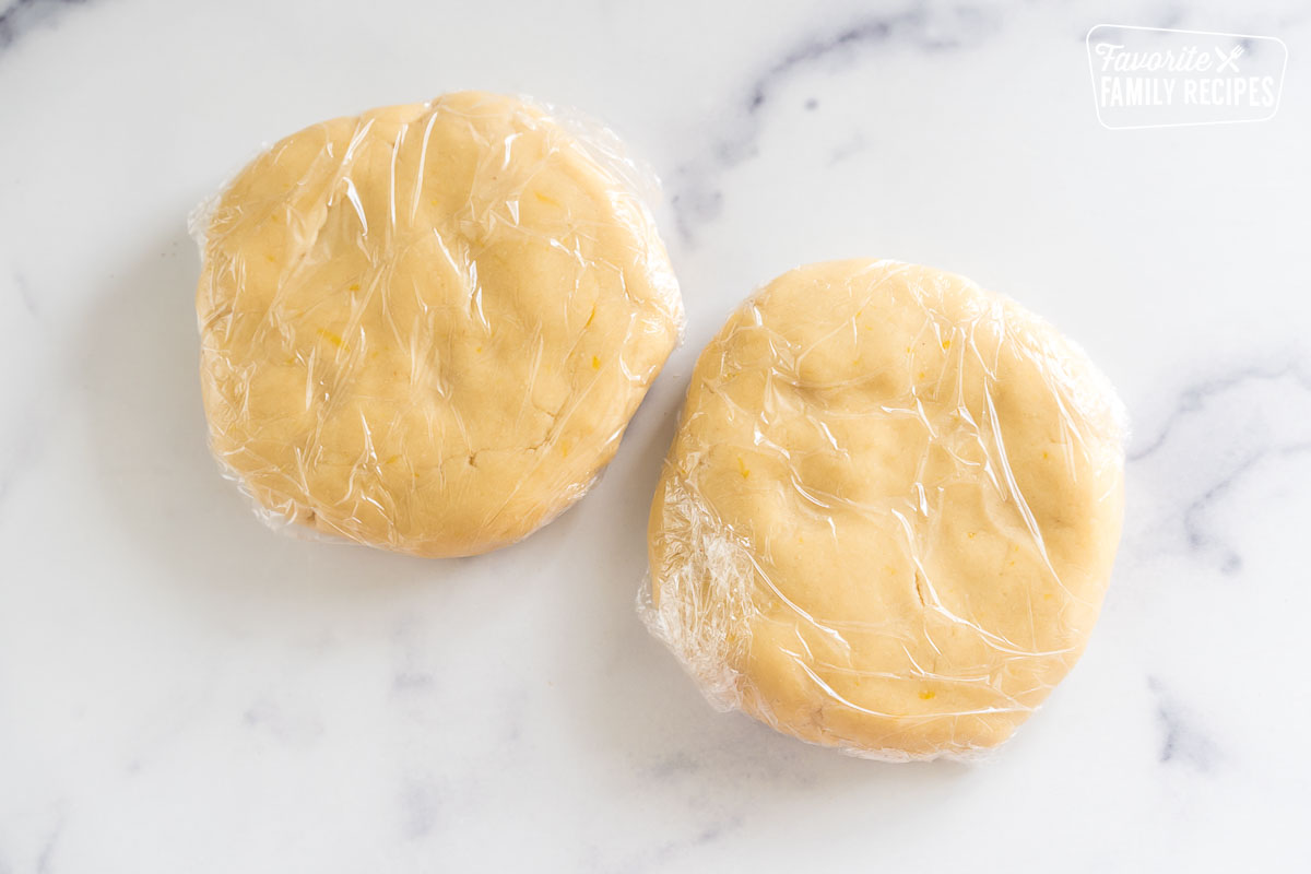 shortbread dough patted into discs and wrapped in plastic wrap