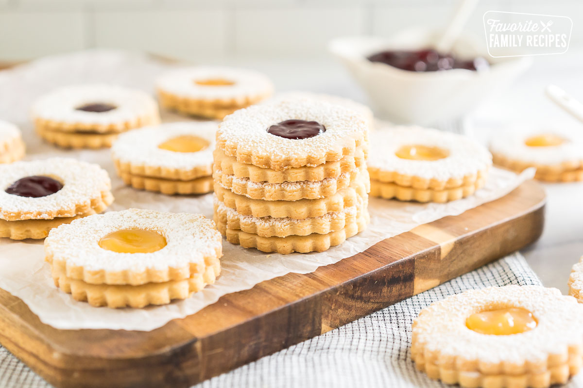 Linzer cookies stacked on a cutting board