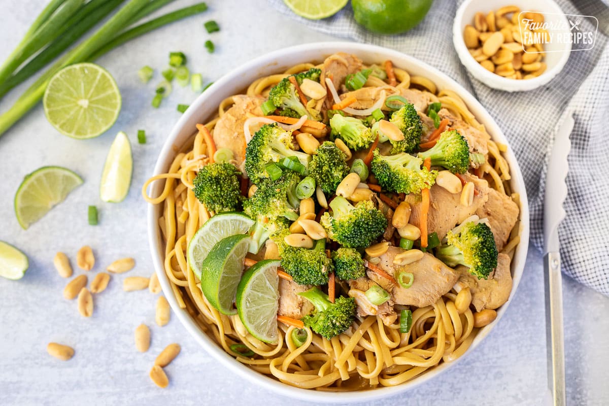 Bowl of Peanut Noodles with sliced limes.